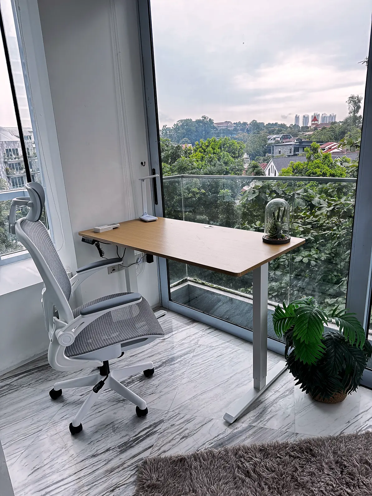 Study desk and ergonomic chair by floor-to-ceiling windows in Fifty Two Stevens Rumah Suite Room 1