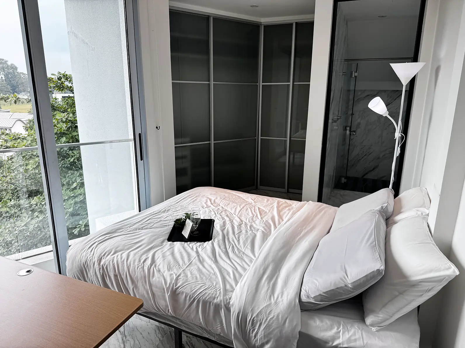 Bed with white linen beside full-height glass doors in Fifty Two Stevens Rumah Suite Room 2