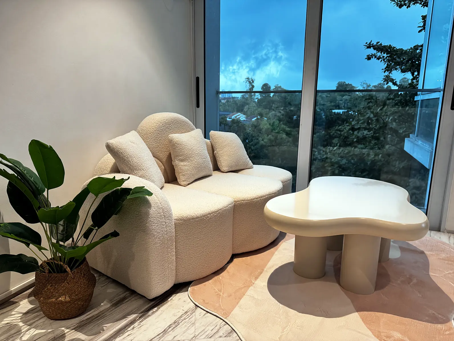 Cosy boucle sofa and coffee table by full-height windows in the Fifty Two Stevens living room