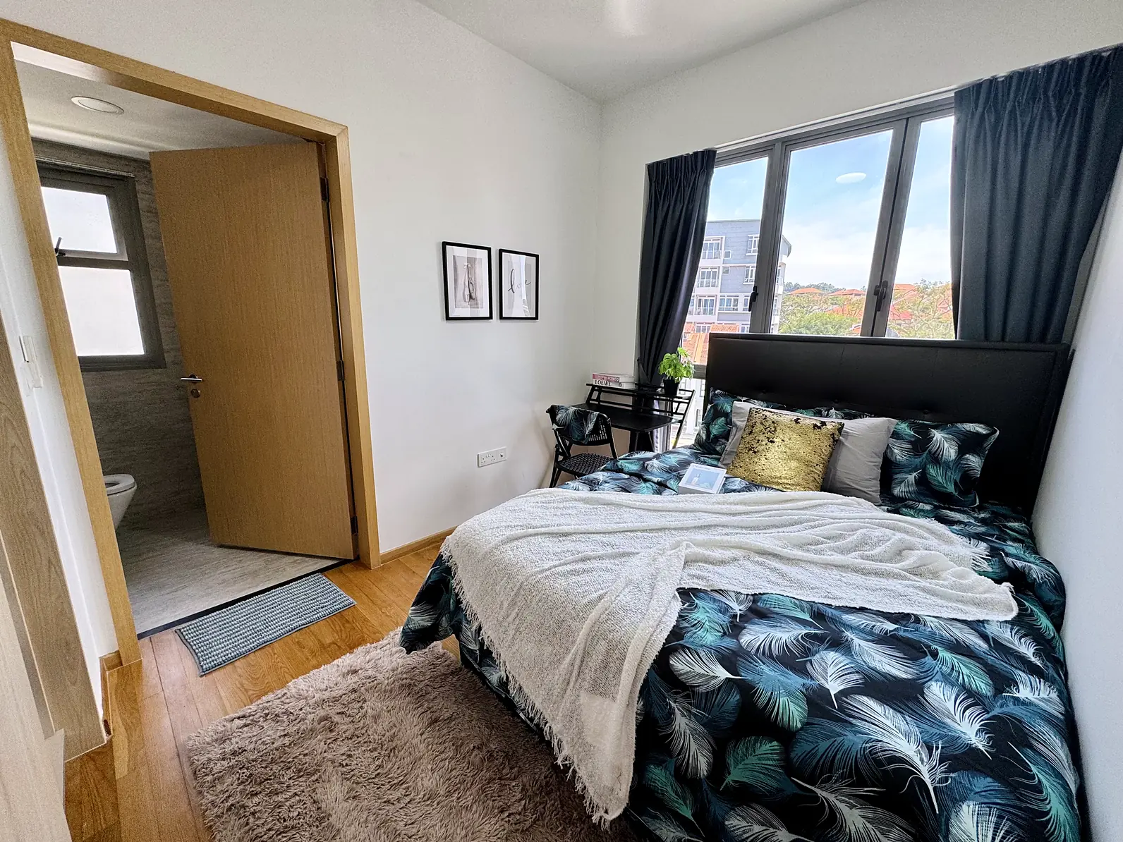 Queen bed and private ensuite bathroom door in Harbour View Gardens Rumah Suite Room 1
